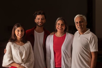 Portrait of happy family standing together in living room