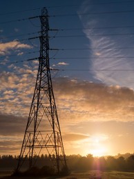 Giant pylon in a field in Radley Village, Autumn sunrise with dramatic sky