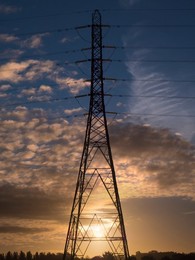 Giant pylon in a field in Radley Village, Autumn sunrise with dramatic sky