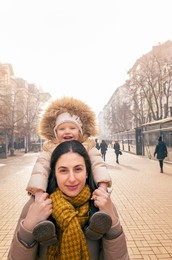 Happy child being carried on mother's shoulders