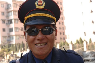 Guardian in uniform in the north-eastern districts of the city of Shanghai: the traditional Shikumen houses. Shanghai, China, Asia