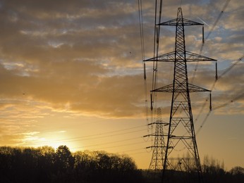 Giant pylon in a field in Sandford Village, winter sunrise