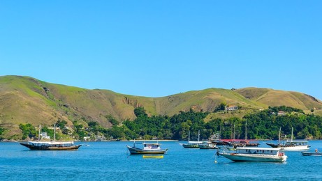 Angra dos Reis, Brazil, Diverse nautical vessels and ships by scenic hills in a natural cove or bay. Angra dos Reis is a popular travel destination in South America