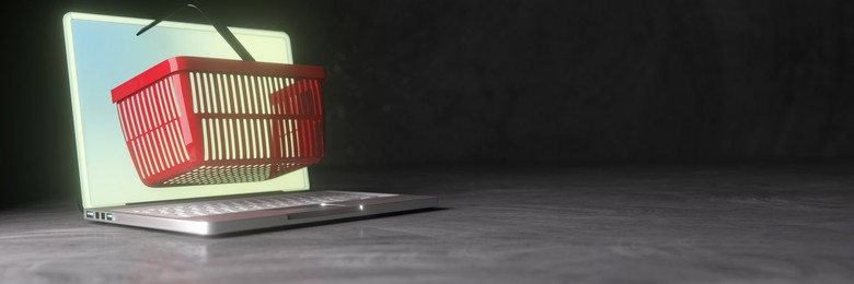 Conceptual shopping basket extruding through a laptop computer screen for online shopping 3d render