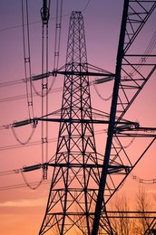 Giant pylons on Kennington Meadows, glowing scarlet winter sunrise