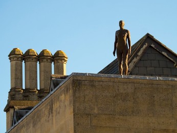 Anthony Gormley public sculpture on a roof in Oxford, winter sunrise