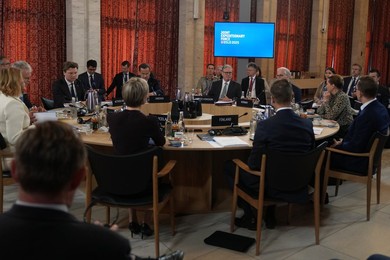 Britain's Prime Minister Keir Starmer, center, sits a round table during the Joi