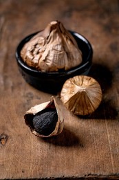 Black Fermented Garlic Whole and Peeled Garlic Clove On Dark Wooden Table. Healthy Eating. Spicy Cooking Ingredients. Asian Kitchen