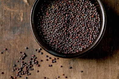 Black Mustard Seeds For Cooking Dijon Mustard In Black Ceramic Bowl On Dark Wooden Table. Healthy Eating. Spicy Cooking Ingredients. Traditional Kitchen. Top View. Close Up