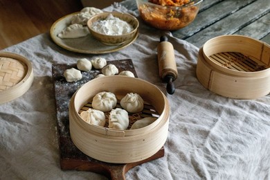 Making Asian Steamed Dumplings with Vegetable Filling. Dumplings Ready To Cook In Bamboo Steamer. Ingredients Nearby. Floured Board. Natural Daylight. Asian Food