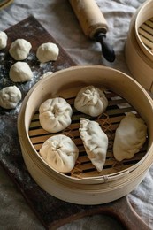 Making Asian Steamed Dumplings with Vegetable Filling. Dumplings Ready To Cook In Bamboo Steamer. Ingredients Nearby. Floured Board. Natural Daylight. Asian Food