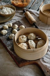 Making Asian Steamed Dumplings with Vegetable Filling. Dumplings Ready To Cook In Bamboo Steamer. Ingredients Nearby. Floured Board. Natural Daylight. Asian Food