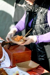Street Food Festival In Europe. Asian Street Food. Fried Seafood Skewers. Vendor In Gloves Hands Over Disposable Plate With Fried Shrimp To Customer.