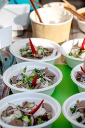 Street Food Festival In Europe. Traditional Vietnamese Pho-bo In Disposable Bowls On Counter. Fast Food Dish from Street Vendor. Hot and Aromatic. Ready To Eat.