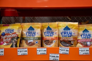 Dog food treats with prices on the shelf in a supermarket in Alaska