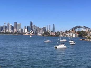 Landscape view of sail boats and yachts moored against Sydney downtown skyline