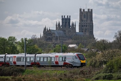 Greater Anglia train passing in front of the Ely Cathedral , Ely, Cambridgeshire, UK.