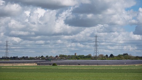 Solar power station and National grid power lines between Soham and wicken, near Ely, cambridgeshire, UK.