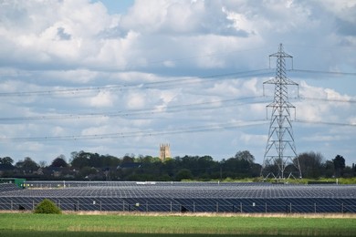 Solar power station and National grid power lines between Soham and wicken, near Ely, cambridgeshire, UK.