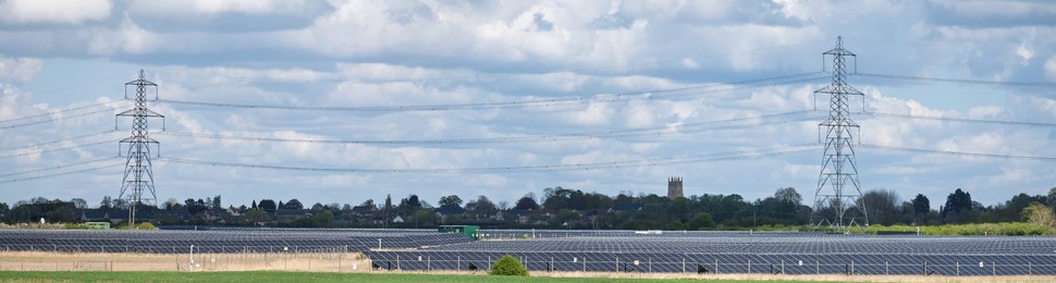 Solar power station and National grid power lines between Soham and wicken, near Ely, cambridgeshire, UK.